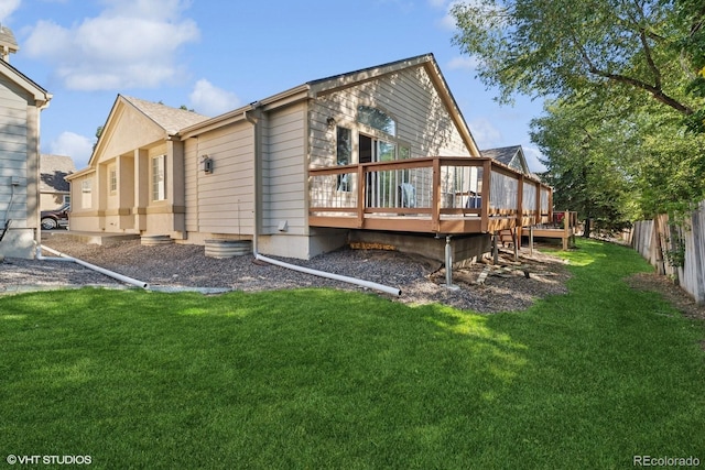 rear view of property featuring a wooden deck and a lawn