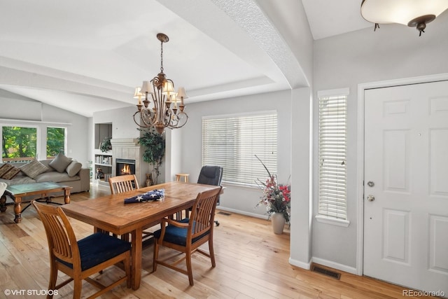 dining area featuring light hardwood / wood-style flooring, a notable chandelier, and lofted ceiling