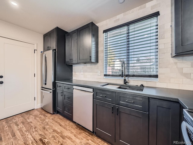 kitchen featuring light hardwood / wood-style floors, sink, stainless steel appliances, and tasteful backsplash