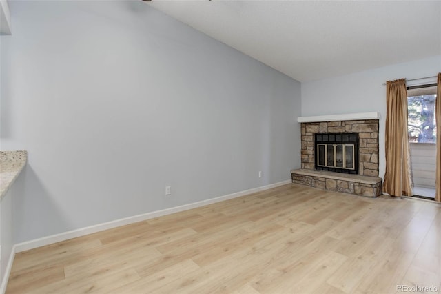 unfurnished living room with a fireplace, wood finished floors, and baseboards