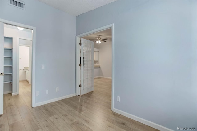 spare room with baseboards, visible vents, ceiling fan, and light wood finished floors