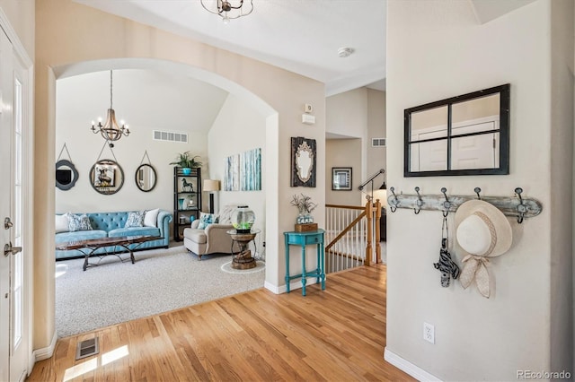 4185 Cheyenne Dr, Larkspur, CO 80118 - foyer with a chandelier, arched walkways, wood finished floors, baseboards, and vaulted ceiling