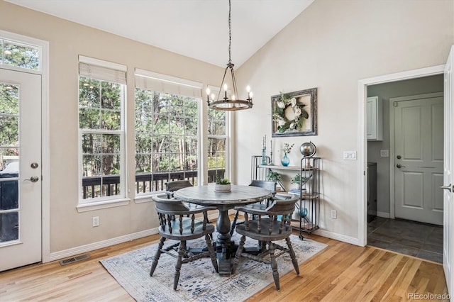 4185 Cheyenne Dr, Larkspur, CO 80118 - dining area with a chandelier, baseboards, light wood-type flooring, and high vaulted ceiling