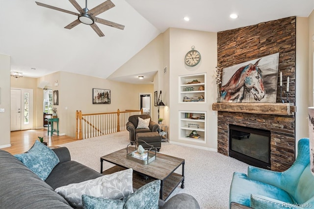 4185 Cheyenne Dr, Larkspur, CO 80118 - carpeted living room featuring built in features, a ceiling fan, a stone fireplace, high vaulted ceiling, and baseboards