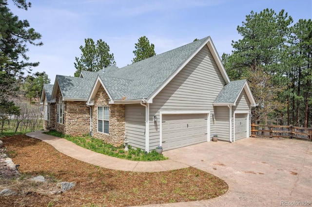 4185 Cheyenne Dr, Larkspur, CO 80118 - view of side of property with a shingled roof, stone siding, driveway, and an attached garage