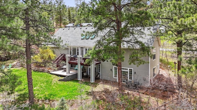 4185 Cheyenne Dr, Larkspur, CO 80118 - back of property with a deck, a yard, and a shingled roof