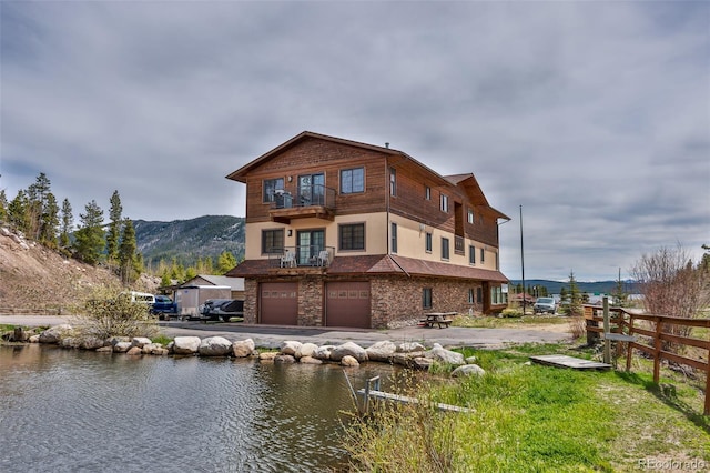 rear view of property with a garage and a mountain view