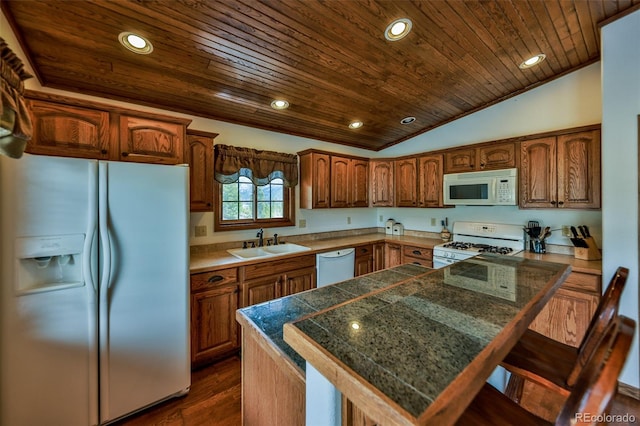 kitchen featuring dark hardwood / wood-style floors, white appliances, sink, a breakfast bar area, and wooden ceiling