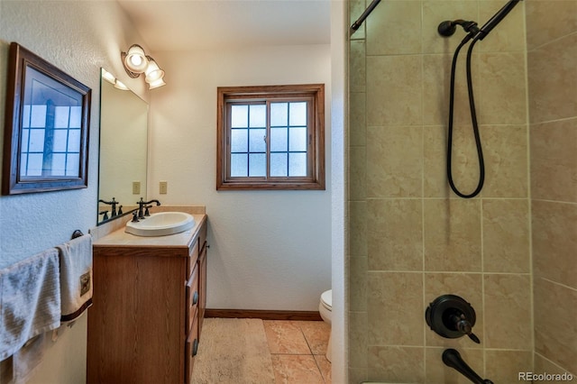 bathroom with tile flooring, toilet, and large vanity