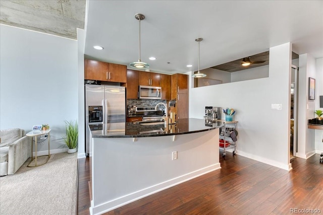 891 14th St Unit 2002, Denver, CO 80202 - kitchen with stainless steel appliances, brown cabinetry, baseboards, tasteful backsplash, and recessed lighting