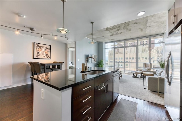 891 14th St Unit 2002, Denver, CO 80202 - kitchen with a sink, open floor plan, stainless steel appliances, dark countertops, and dark wood-type flooring