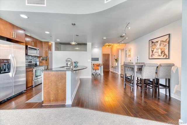 891 14th St Unit 2002, Denver, CO 80202 - kitchen featuring stainless steel appliances, dark countertops, brown cabinets, a sink, and baseboards