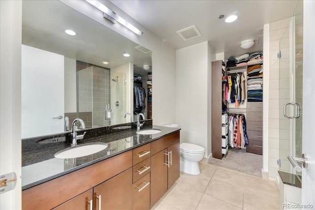 891 14th St Unit 2002, Denver, CO 80202 - bathroom with a spacious closet, double vanity, a shower stall, tile patterned floors, and recessed lighting
