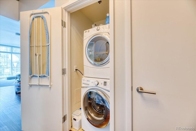 891 14th St Unit 2002, Denver, CO 80202 - washroom featuring stacked washer / drying machine and wood finished floors