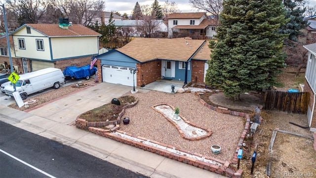 view of front of property with fence, an attached garage, a residential view, concrete driveway, and brick siding