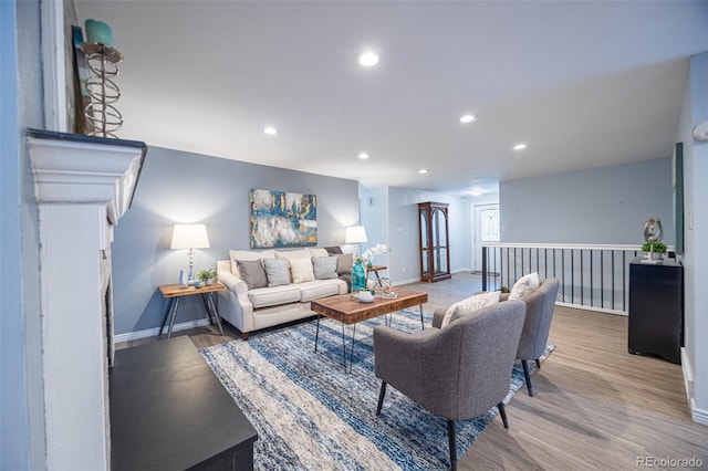 living area with recessed lighting, wood finished floors, and baseboards