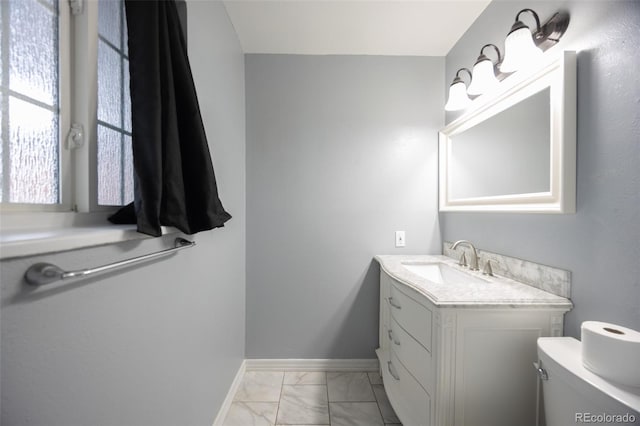 bathroom with baseboards, toilet, marble finish floor, and vanity