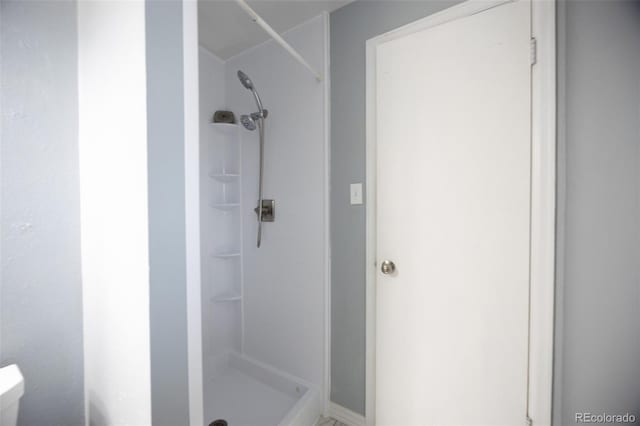 full bathroom with a stall shower and toilet