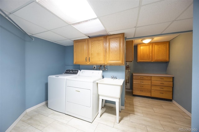 clothes washing area featuring cabinet space, baseboards, and washer and clothes dryer