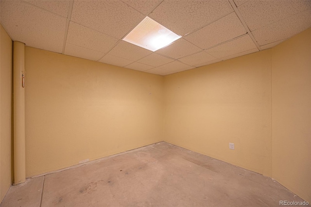 interior space featuring a paneled ceiling and unfinished concrete flooring