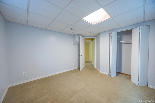 unfurnished bedroom with baseboards, visible vents, carpet floors, and a paneled ceiling