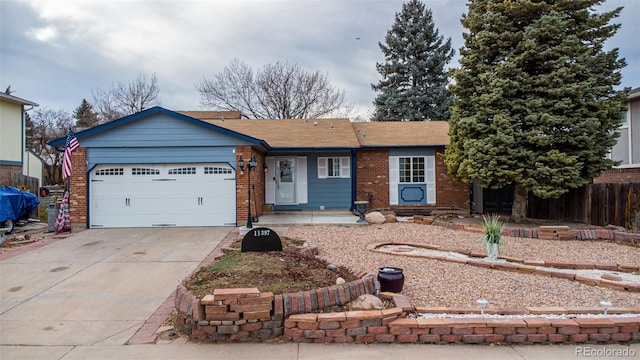 ranch-style home with brick siding, an attached garage, driveway, and fence