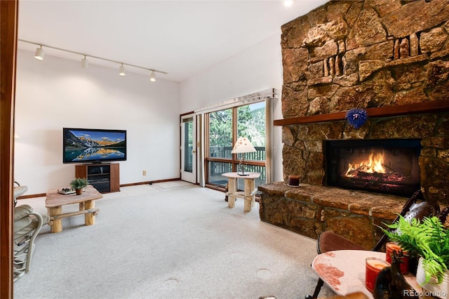 living room featuring a fireplace, light colored carpet, and rail lighting