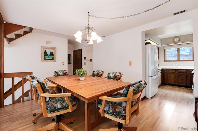 dining room featuring an inviting chandelier and light hardwood / wood-style flooring