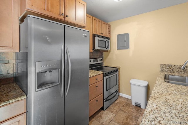 kitchen with electric panel, stainless steel appliances, decorative backsplash, and sink