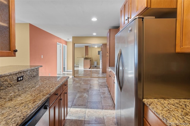 kitchen with appliances with stainless steel finishes and light stone counters