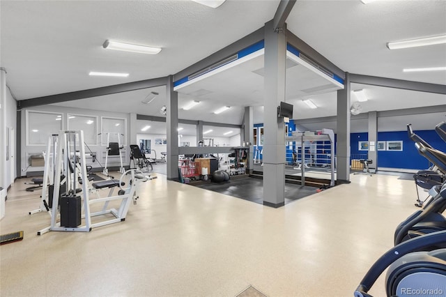 gym featuring lofted ceiling and a textured ceiling