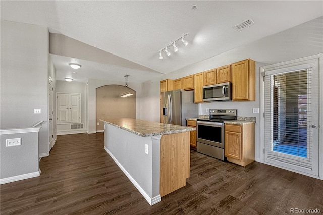 kitchen with dark hardwood / wood-style floors, a kitchen island, stainless steel appliances, and lofted ceiling