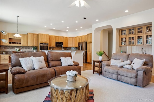 living room with recessed lighting, arched walkways, and a ceiling fan