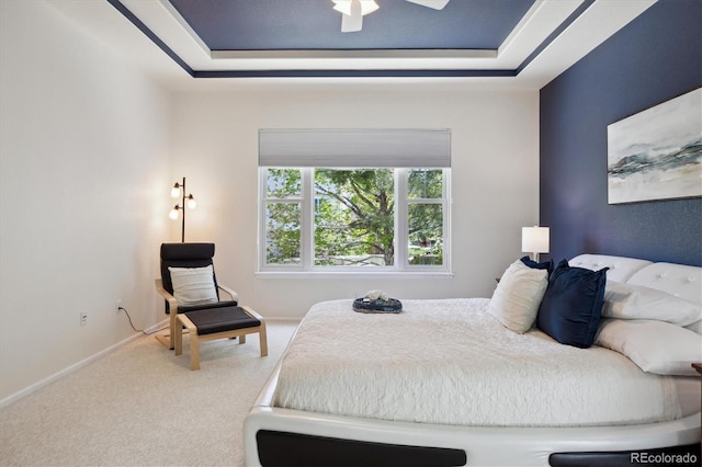 carpeted bedroom with baseboards and a tray ceiling