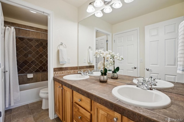 full bathroom featuring double vanity, a sink, shower / bath combination with curtain, and toilet