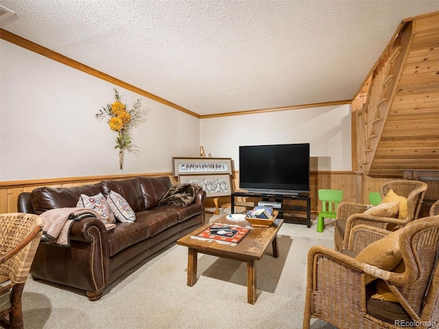 carpeted living room featuring a wainscoted wall, wooden walls, crown molding, and a textured ceiling