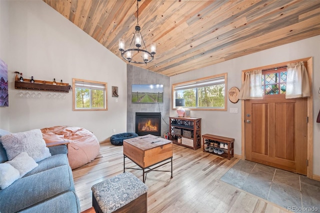 332 Harris St, Bailey, CO 80421 - living area with lofted ceiling, wooden ceiling, a chandelier, baseboards, and a tiled fireplace