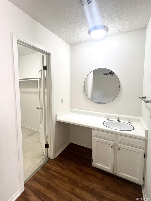 bathroom with hardwood / wood-style floors, vanity, and a textured ceiling