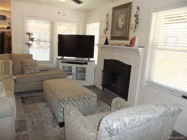 living room with a fireplace and a ceiling fan