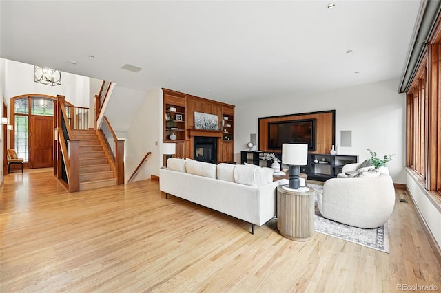 1351 S Milwaukee St, Denver, CO 80210 - living area featuring light wood-type flooring, stairs, a chandelier, and a glass covered fireplace