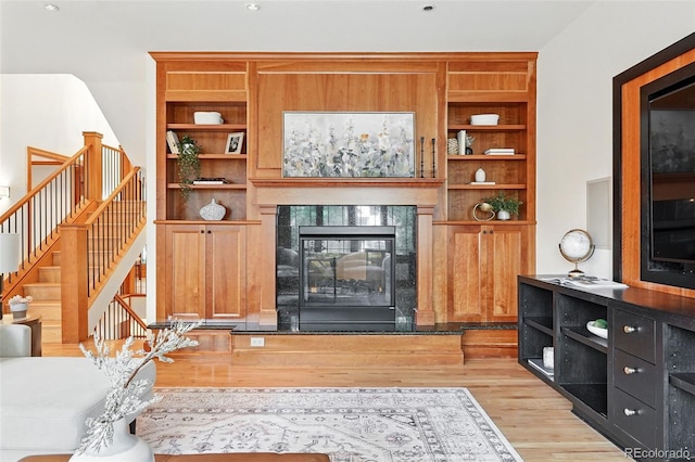 1351 S Milwaukee St, Denver, CO 80210 - living room with light wood-type flooring, stairs, a tile fireplace, and built in shelves
