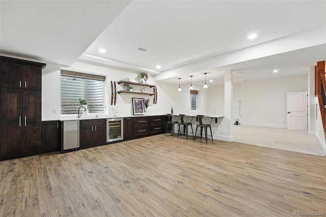 1351 S Milwaukee St, Denver, CO 80210 - kitchen featuring beverage cooler, recessed lighting, light wood finished floors, dark brown cabinets, and a sink