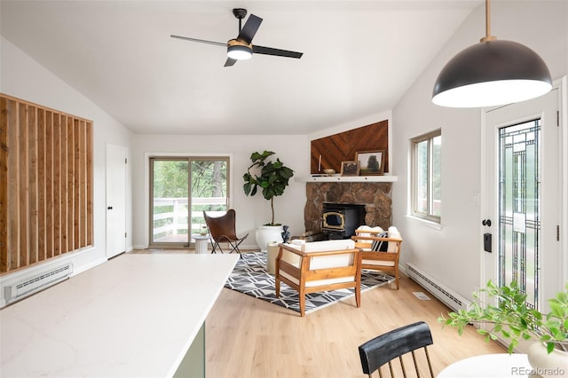 19424 Silver Ranch Rd, Conifer, CO 80433 - living area featuring a baseboard radiator, light wood-style flooring, lofted ceiling, a wood stove, and ceiling fan