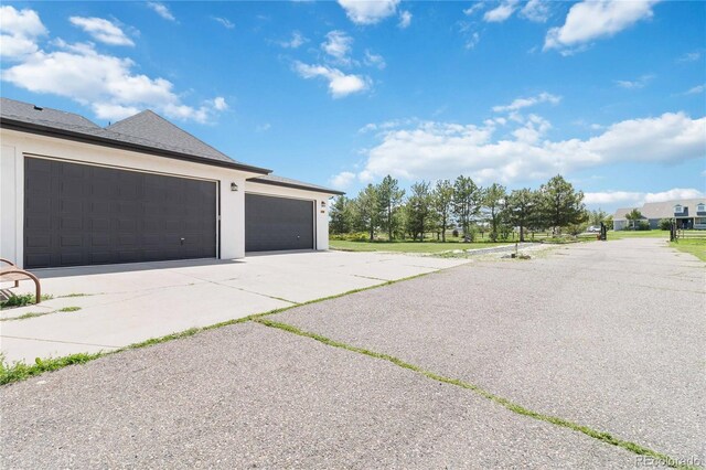 1550 Ajax St, Strasburg, CO 80136 - garage featuring asphalt driveway