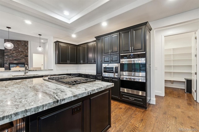 12939 Wabash Ct, Thornton, CO 80602 - kitchen featuring appliances with stainless steel finishes, a sink, light stone countertops, dark wood finished floors, and recessed lighting