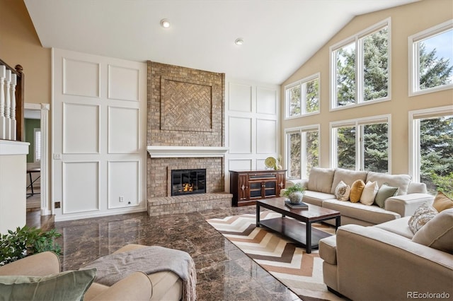 5320 S Geneva St, Englewood, CO 80111 - living area featuring a decorative wall, plenty of natural light, a brick fireplace, high vaulted ceiling, and marble tiled flooring