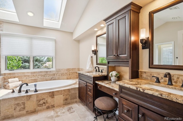 5320 S Geneva St, Englewood, CO 80111 - full bathroom featuring vaulted ceiling, a skylight, a garden tub, two vanities, and stone finish flooring