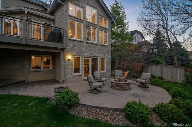 5320 S Geneva St, Englewood, CO 80111 - back of property featuring an outdoor fire pit, brick siding, a balcony, a patio area, and fence