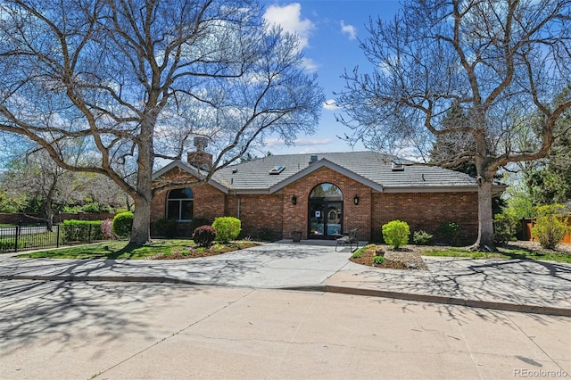 5320 S Geneva St, Englewood, CO 80111 - view of front of home featuring brick siding, fence, a chimney, and concrete driveway
