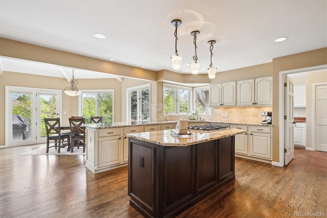 5320 S Geneva St, Englewood, CO 80111 - kitchen with a kitchen island, tasteful backsplash, light stone counters, pendant lighting, and dark wood-style floors